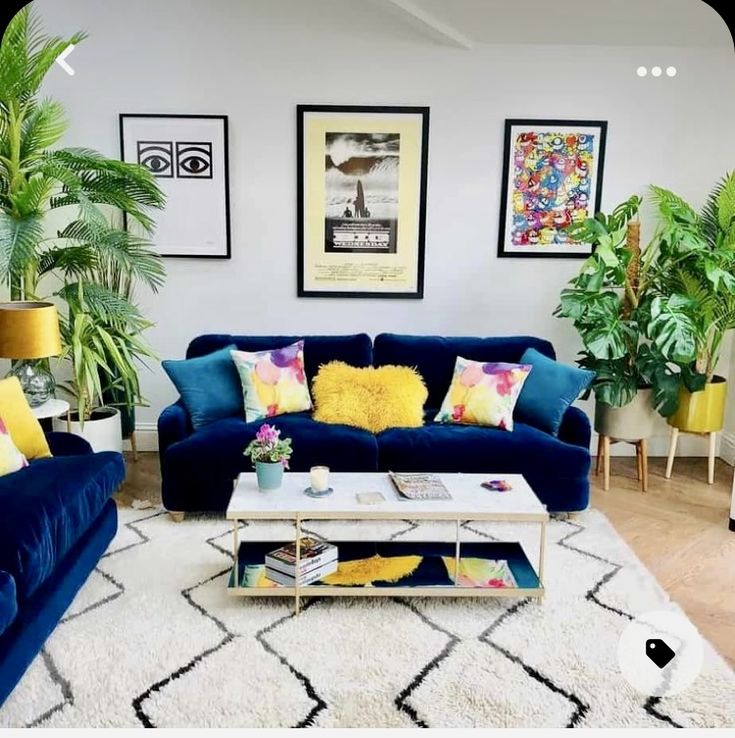 a living room filled with blue couches and yellow pillows