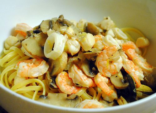 a white bowl filled with pasta and shrimp