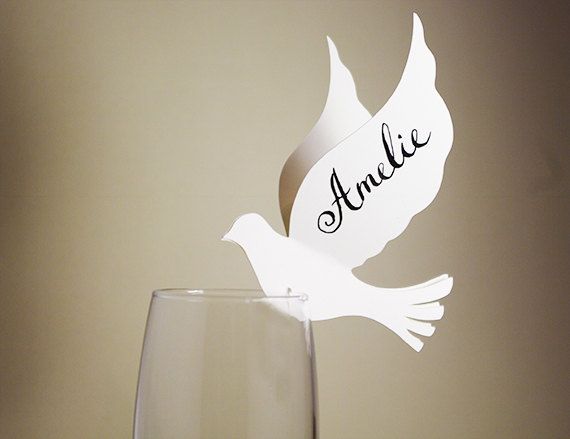 a wine glass with a white bird on it next to a paper cutout that says annie