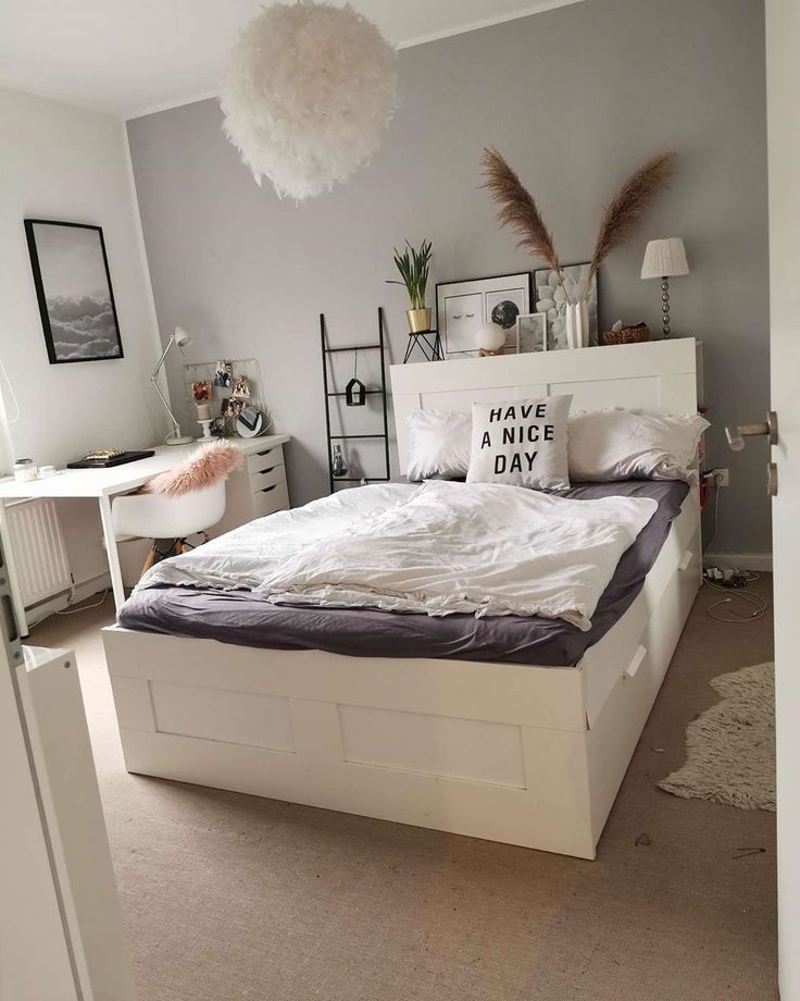 a bedroom with a large bed and white furniture