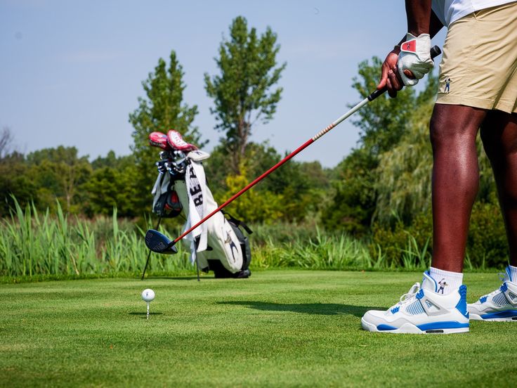 a man hitting a golf ball on the green