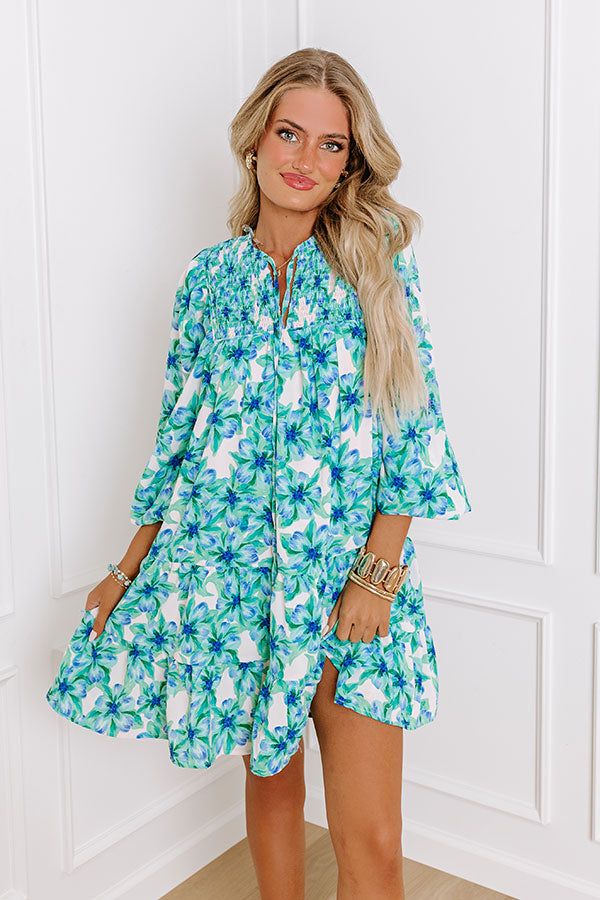 - Make memories one mimosa at a time in this darling dress! - Lightweight material with a floral print and a built-in skirt lining - A v-cut neckline with a tie - A smocked detail - Long, loose sleeves with elastic cuffs - A flowy silhouette that ends in A mini dress length hemline Measurements S : Bust 34", Hip 42", Length 34", Sleeve Length 23.5", Waist 38". M : Bust 36", Hip 44", Length 34", Sleeve Length 23.5", Waist 40". L : Bust 38", Hip 46", Length 35.5", Sleeve Length 24", Waist 42". Summer Mini Dress With Split Neck, Green Knee-length Beach Dress, Spring Turquoise Printed Dresses, Turquoise V-neck Summer Dress, Spring Vacation Dress With Split Neck, Green V-neck Sundress For Brunch, Printed Turquoise Dress For Spring, Green Summer Mini Dress For Brunch, Green Sundress For Spring Garden Party