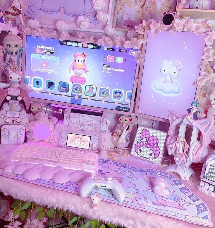 there is a pink desk with hello kitty decorations on it and a laptop in front of the monitor