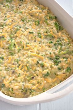 a casserole dish with broccoli and cheese in it on a white table