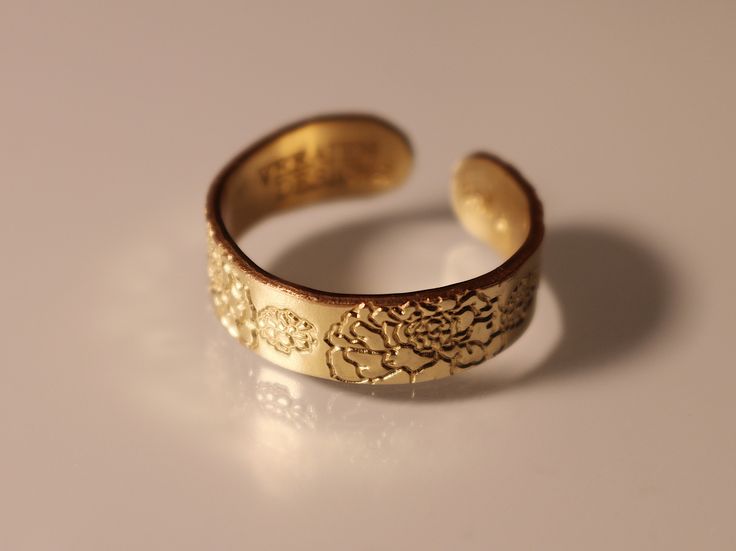 This Marigold Ring is an elegant and thoughtful choice for those born in October. Featuring a delicate marigold design, it is the perfect accessory for anyone looking to celebrate their birth flower. The ring is crafted with high-end materials and finished with a lifetime of durability. Its elegant design ensures it will stand the test of time, making it a timeless keepsake. The marigold will serve as a beautiful reminder of the wearer's October birth month for years to come. The ring is designe Adjustable Gold Flower Ring In Brass, Adjustable Gold Flower Ring, Adjustable Gold Brass Flower Ring, Rose Gold Brass Wedding Ring, Adjustable Gold Midi Rings For Wedding, Gold Flower Ring Gift, Flower Shaped Gold Midi Rings For Weddings, Gold Promise Jewelry With Birth Flower, Gold Open Flower Ring As Gift