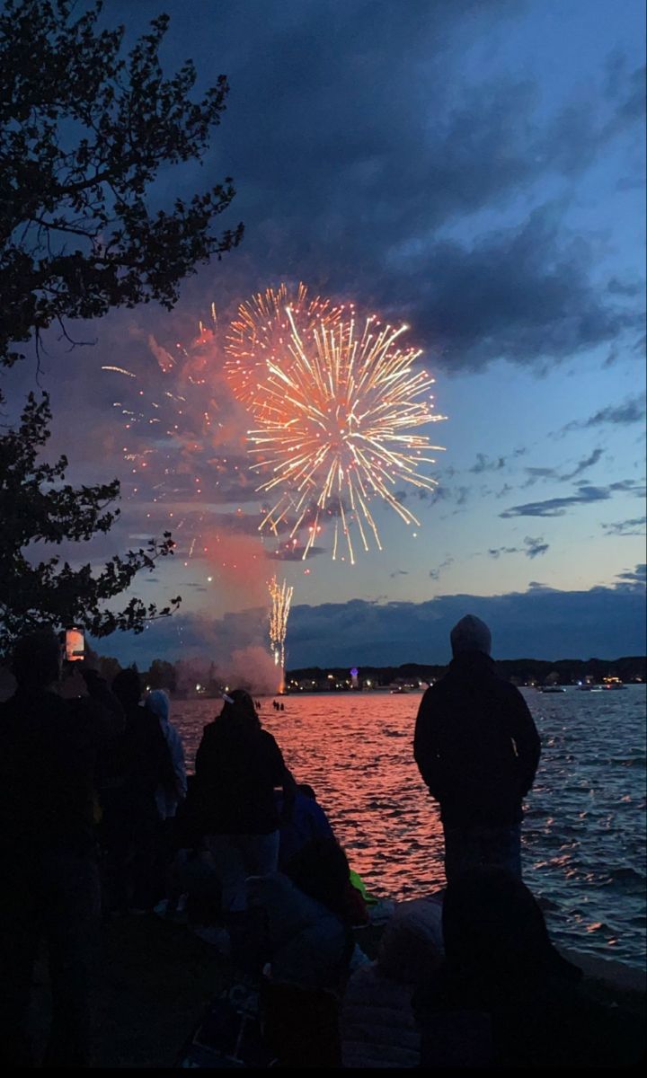 people watching fireworks on the water at night