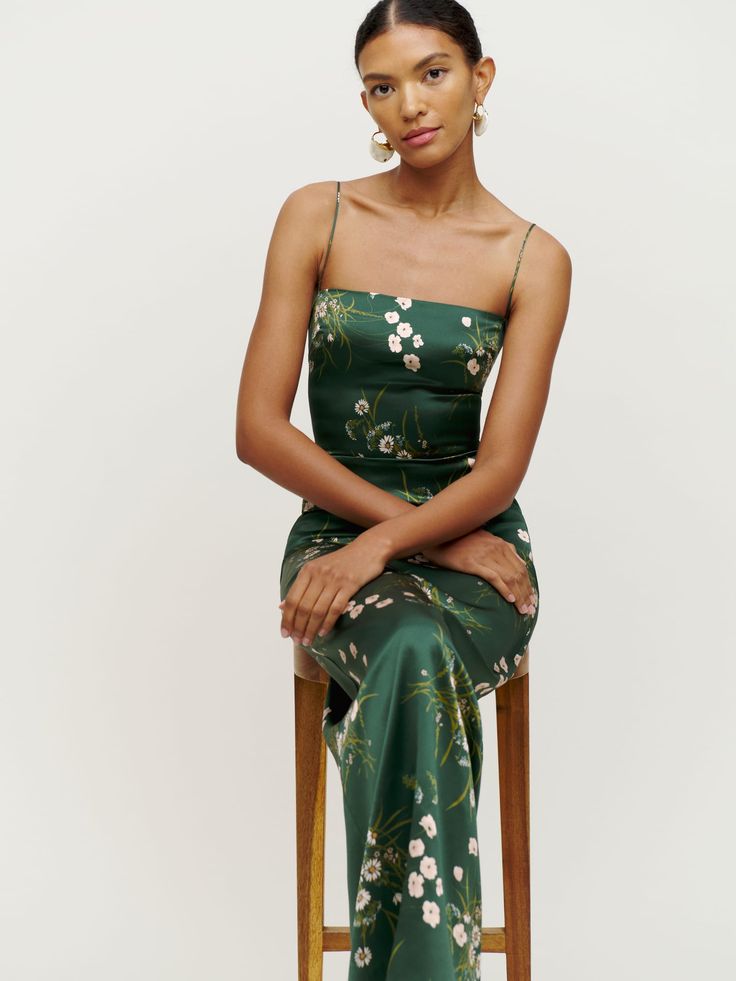 a woman in a green dress sitting on a chair