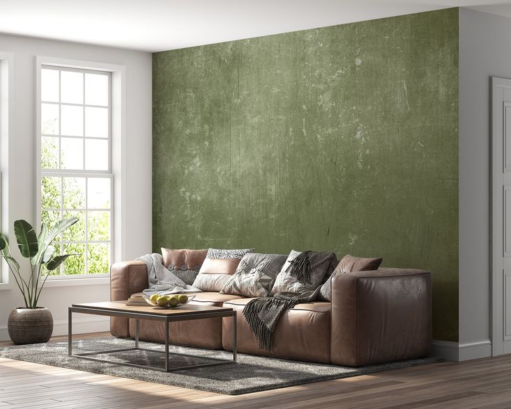 a living room with green walls and leather furniture