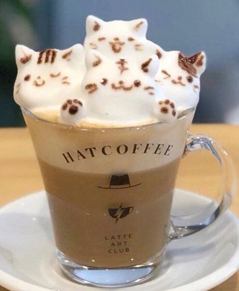 two cats on top of each other in a coffee cup with whipped cream and chocolate