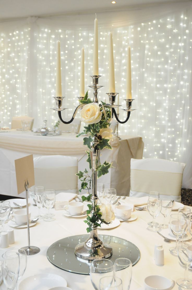 the table is set with white flowers and candles for an elegant wedding breakfast or bridal party