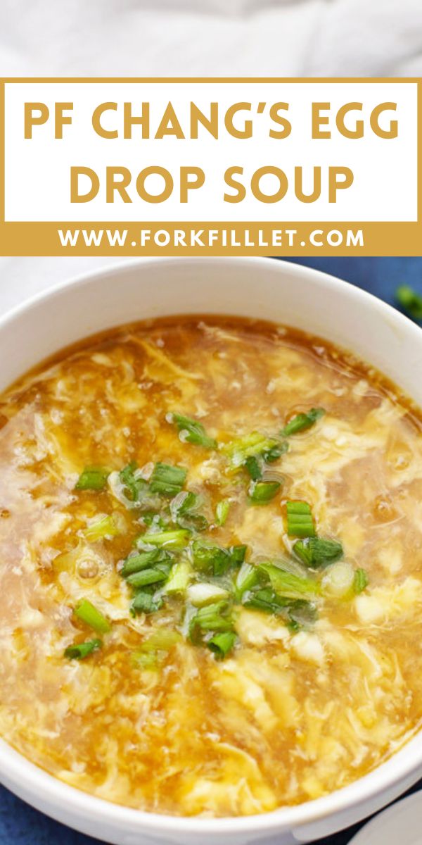 an egg drop soup in a white bowl with green onions