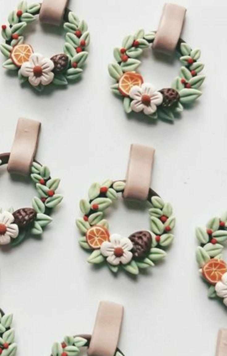 several christmas wreaths with fruit and leaves on them are arranged next to each other