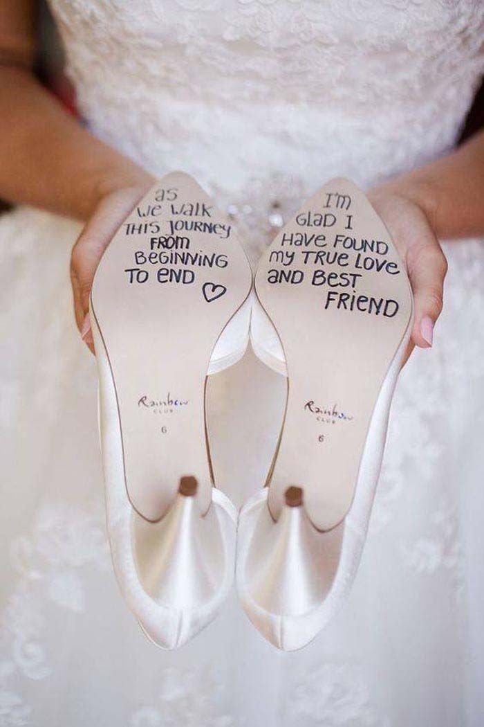 someone is holding two wedding shoes with words on the bottom, and one in the middle