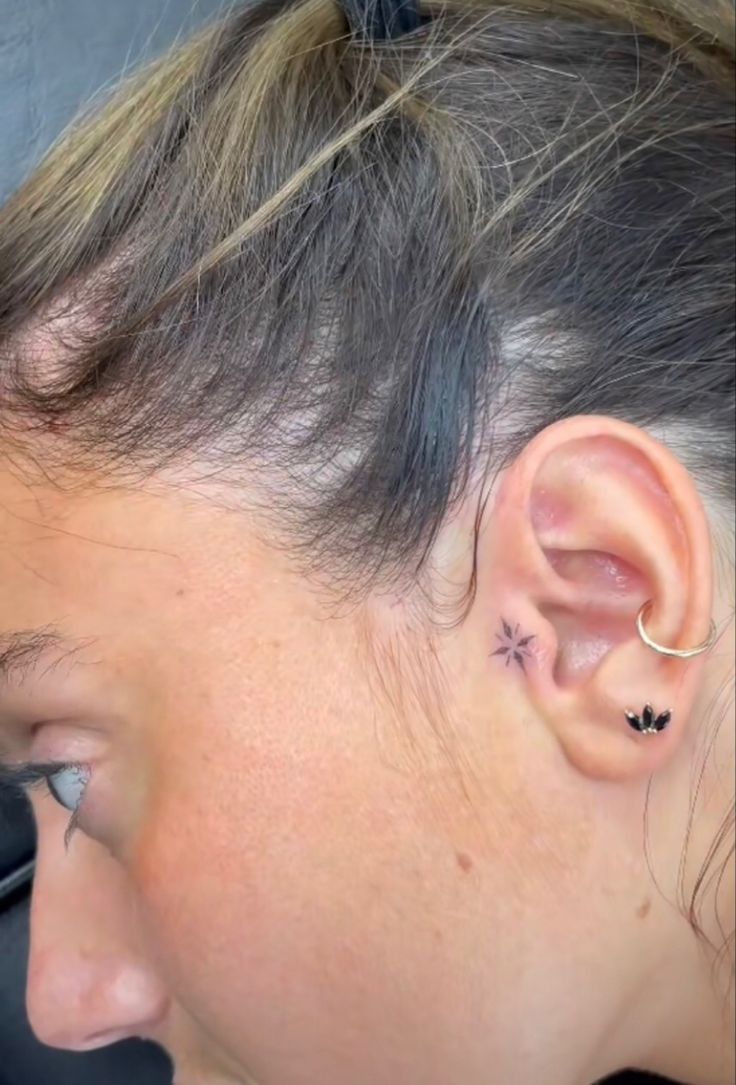 a close up of a person with ear piercings on their ears and behind the ear