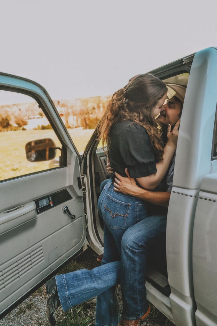 a man and woman hugging in the back of a truck