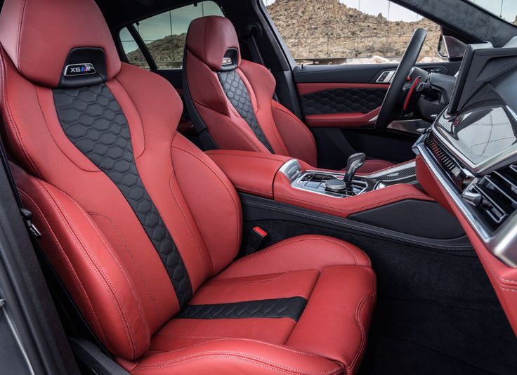 the interior of a sports car with red leather and black stitching on the seats