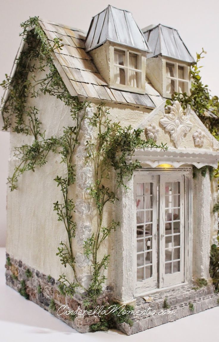 a model house with ivy growing on the roof and windows, in front of a white background