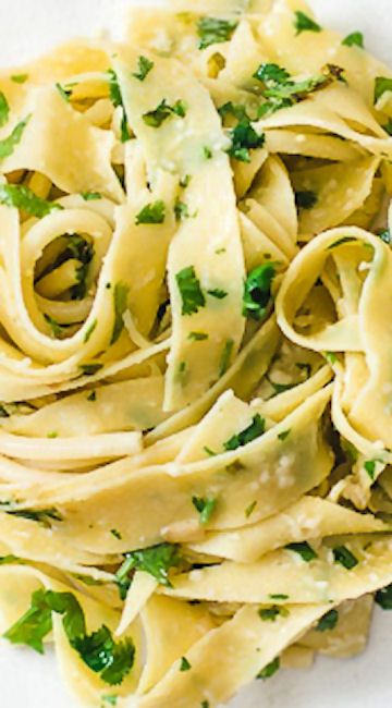 a plate of pasta with parsley on top