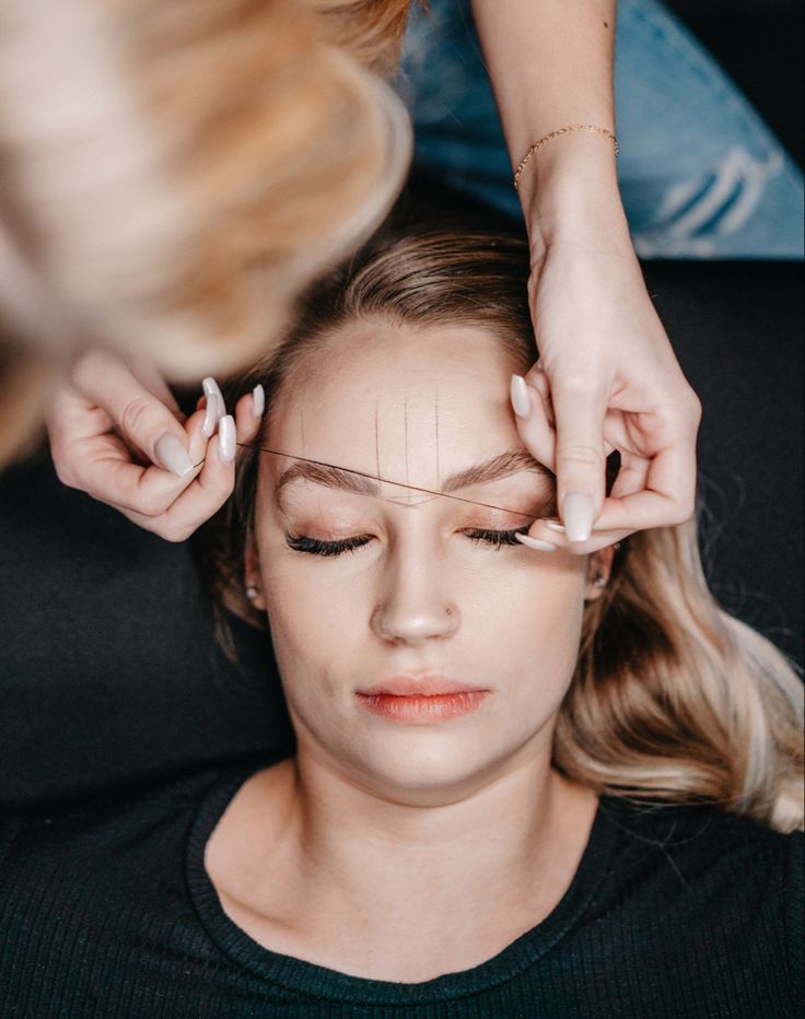 a woman is getting her hair done by another woman who is cutting her hair with scissors