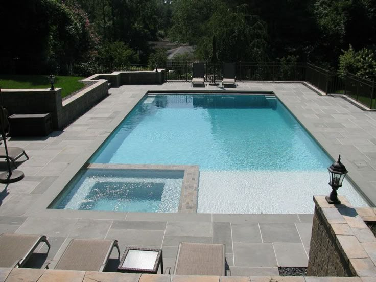 an empty swimming pool surrounded by patio furniture