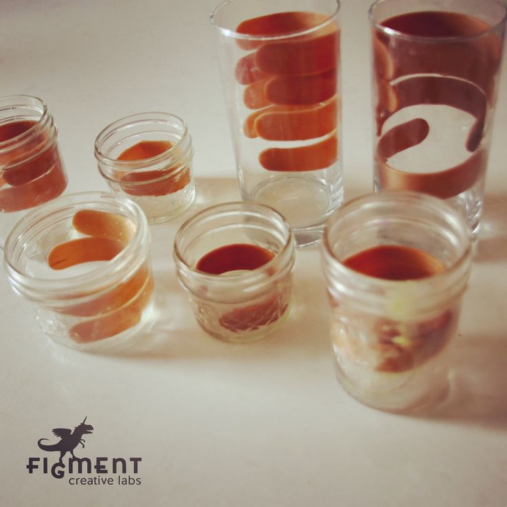 several glasses filled with liquid sitting on top of a white countertop next to each other