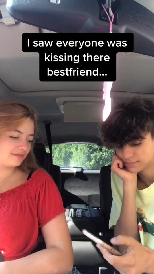 two people sitting in the back seat of a car looking at their cell phones and texting, i saw everyone was kissing there best friend