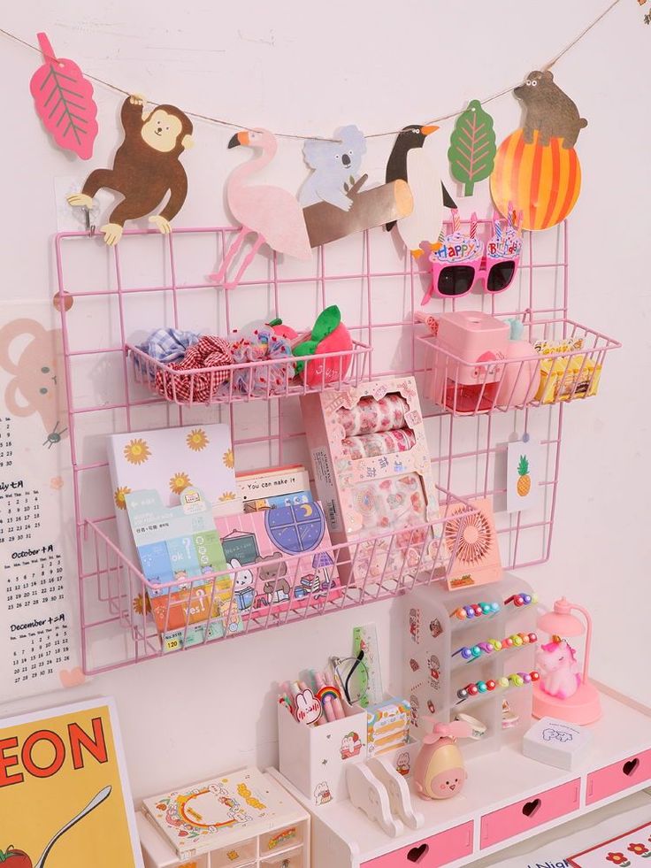 a pink shelf filled with lots of items on top of a white table next to a wall