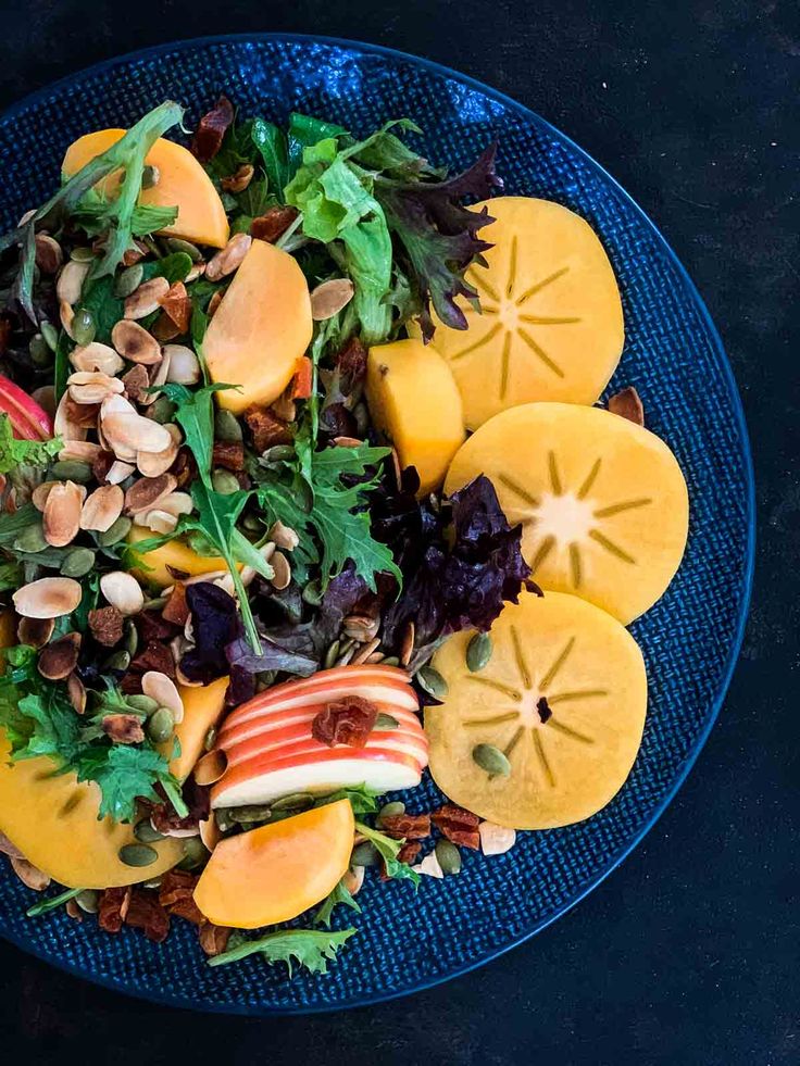 a blue plate topped with fruit and nuts