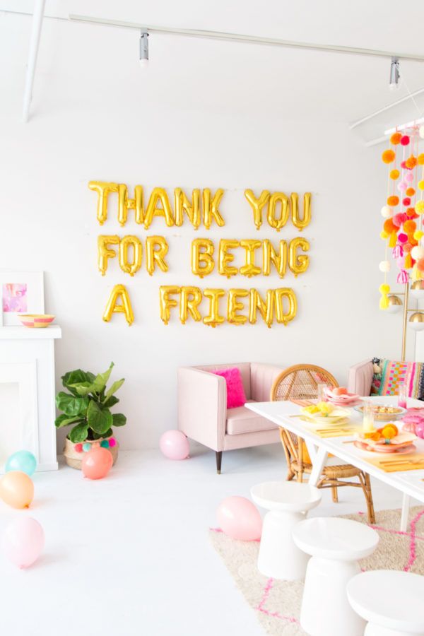 a white room with balloons and decorations on the walls, along with a sign that says thank you for being a friend