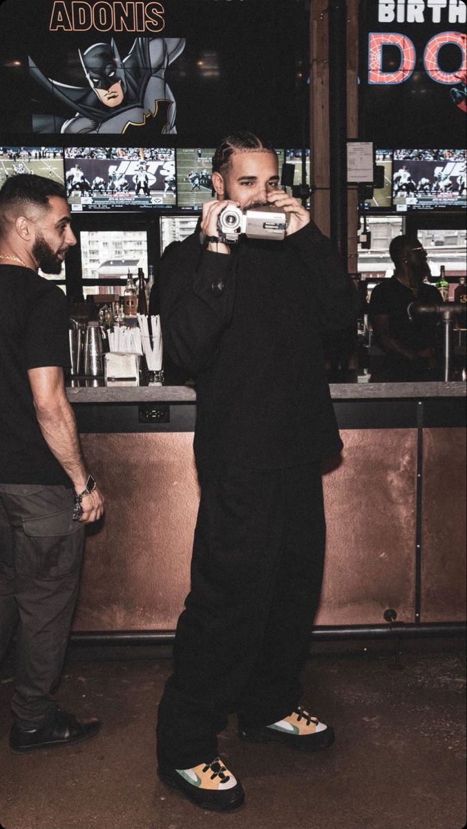 two men standing in front of a bar taking pictures