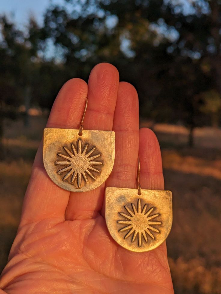 Hammered brass makes up these boho statement earrings! Sun shapes were soldered to the backplates, and then oxidized. This is a one of a kind pair of earrings, you will get the exact ones in the photos. Even the ear wires on these are handmade! All metals used are solid raw brass. Add a golden glow and some sunshine to your summer style with these! Handmade in my shop in the mountains of California. Fast and free shipping on every order! Hand Forged Bohemian Bronze Earrings, Hand Forged Bronze Bohemian Earrings, Rustic Gold Metal Earrings, Rustic Brass Drop Earrings, Nickel-free Bronze Artsy Earrings, Rustic Gold Brass Earrings, Rustic Gold Drop Earrings, Artsy Brass Drop Earrings, Artsy Gold Brass Earrings