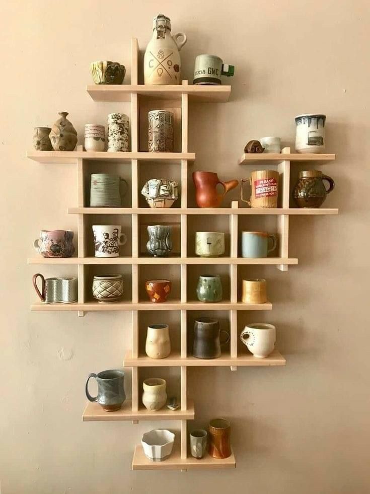 a wall shelf filled with lots of cups and mugs on top of wooden shelves