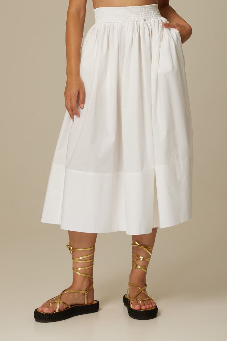 The Sofia midi skirt in crisp white is cut from Italian organic cotton poplin in a breezy full shape and features a comfortable elasticized waist, side seam pockets and a concealed zipper. Wear yours with the matching Daria bustier or one of our signature sweaters. Fit: Bianca, our model is 5.8” or 1.77 m tall and wears size 1. The skirt measures approximately 32" (80cm) long. Content: 100% organic cotton poplin. Care instructions: - For easy care, professional wash and fold is recommended. - Ma White Cotton Midi Bottoms, White Midi Length Bottoms For Summer, White Midi Bottoms For Summer, White Midi Length Bottoms With Elastic Waistband, White Midi Bottoms With Elastic Waistband, White Midi-length Bottoms For Summer, White Cotton Skirt With Elastic Waistband, White Voluminous Skirt For Daywear, White Relaxed Cotton Skirt