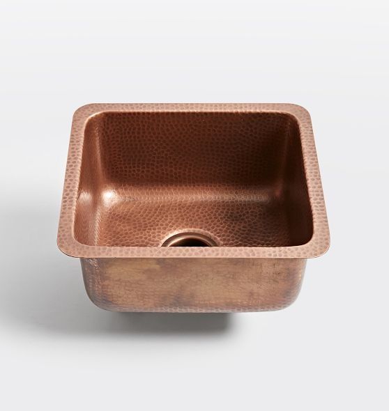 a copper sink with a square bowl on the bottom