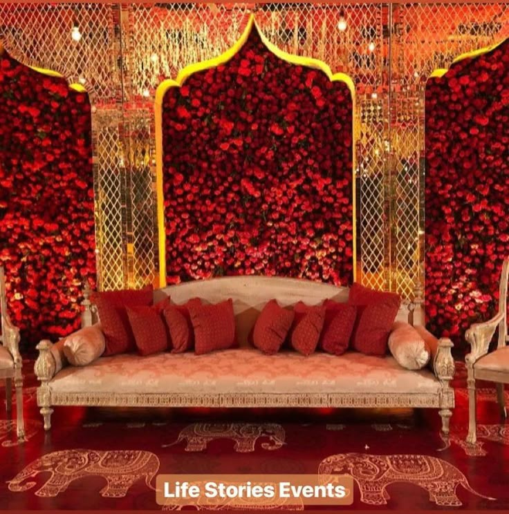 a couch and chairs are in front of a red wall with flowers on it that says life stories events