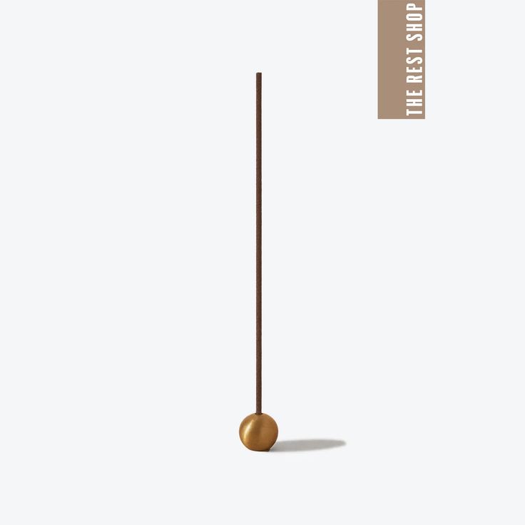 an object that is standing in the middle of a white background with a gold ball on it