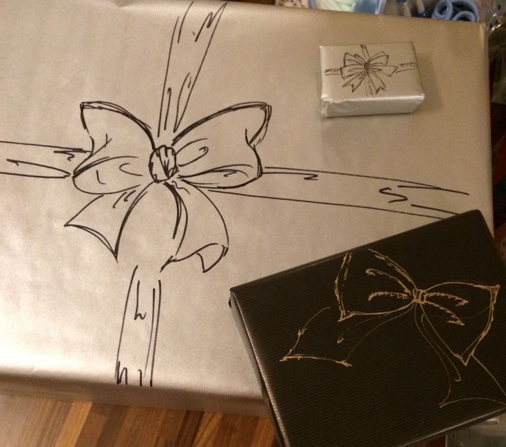 a gift wrapped in white paper with a bow on it and some other wrapping material