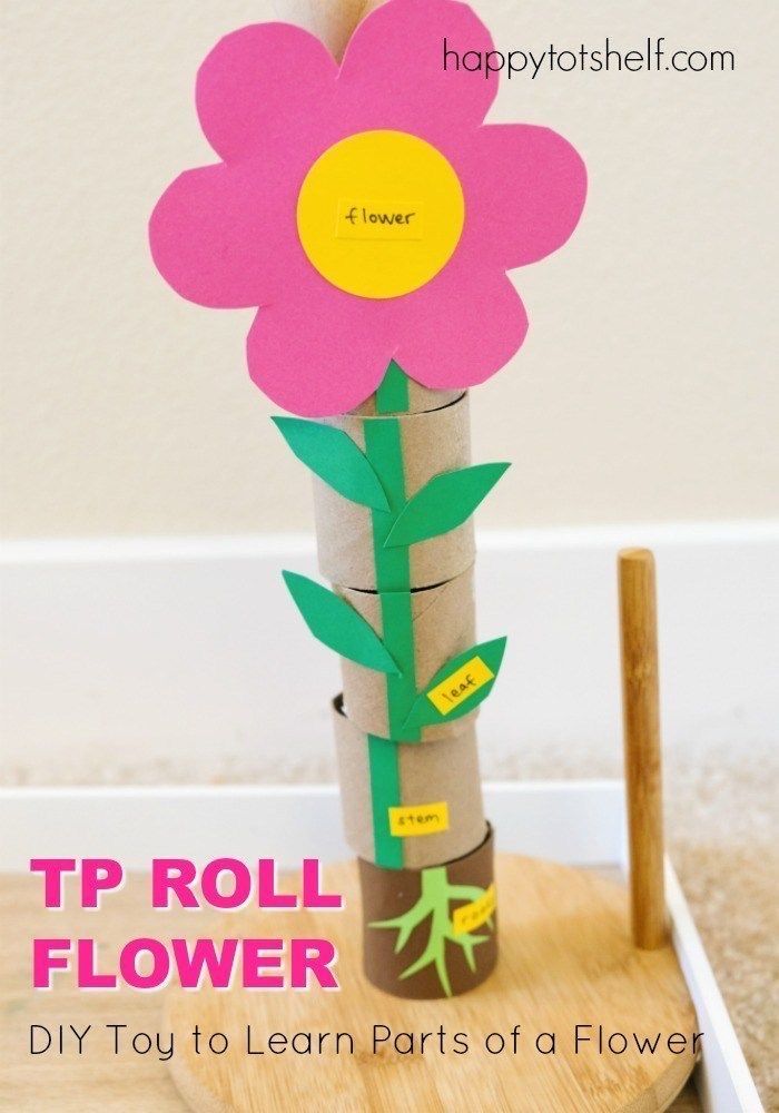 a flower made out of toilet paper sitting on top of a wooden stand with the words tp roll flower