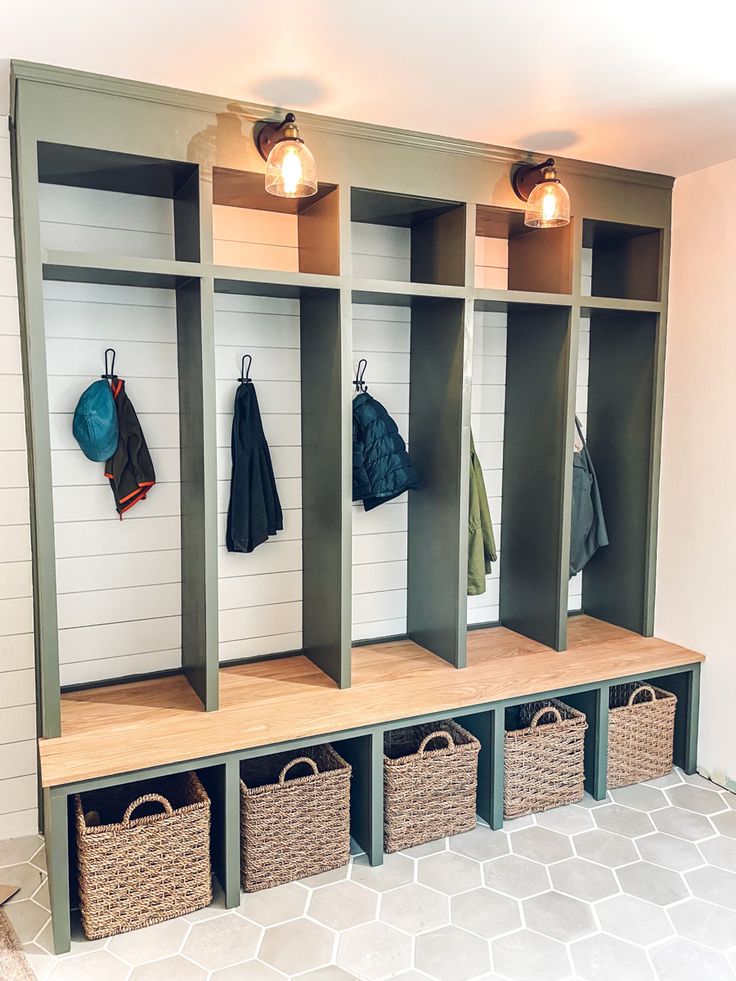 an organized mudroom with baskets and umbrellas