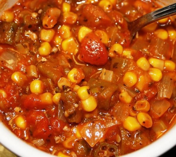 a white bowl filled with corn and tomato soup