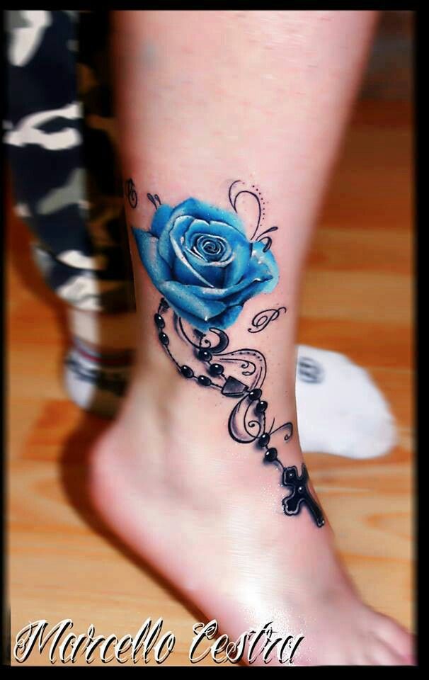 a blue rose tattoo on the foot of a woman's left leg and ankle