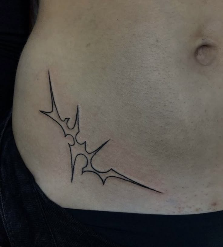 a woman's stomach with a tattoo design on the bottom part of her belly