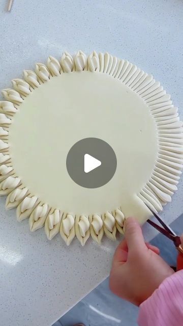 a person cutting up some food on top of a white table with scissors and plastic wrap