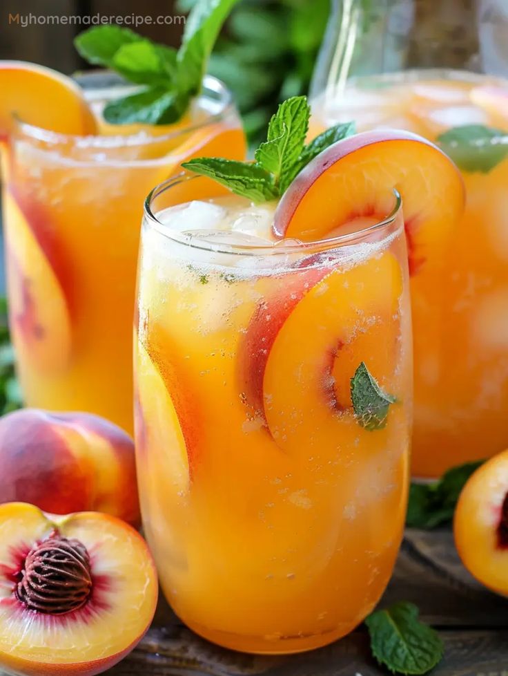 two glasses filled with peach iced tea next to sliced peaches