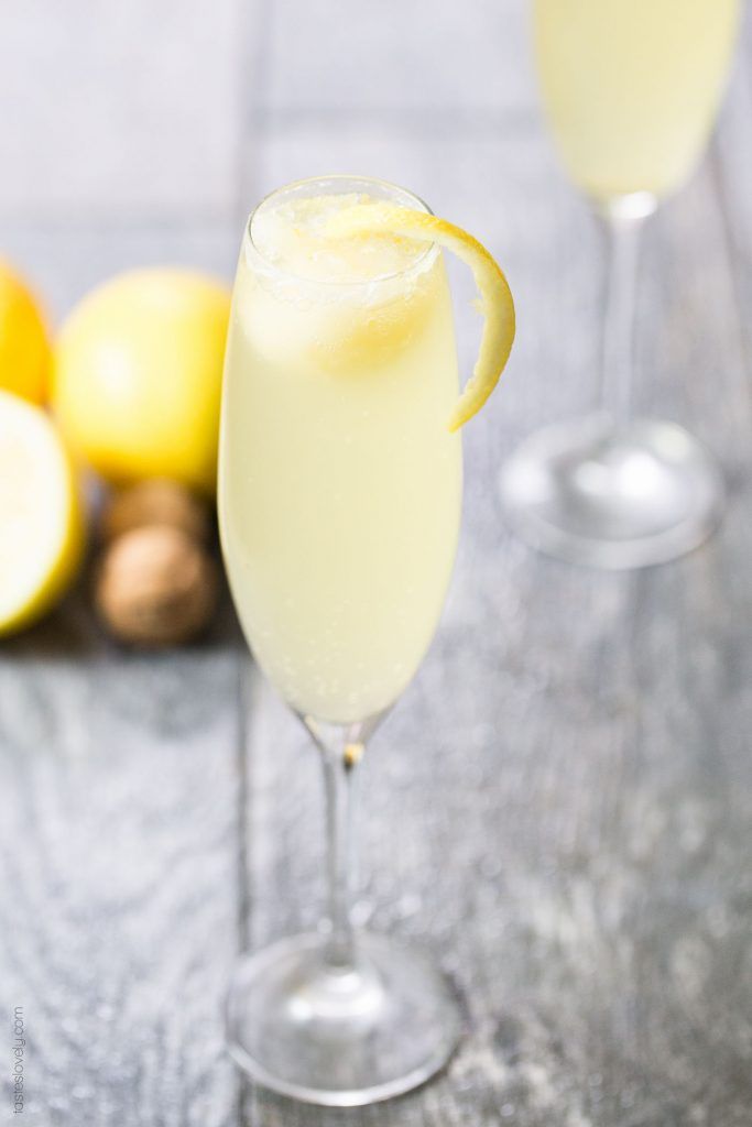 two glasses filled with lemonade sitting on top of a table next to sliced lemons