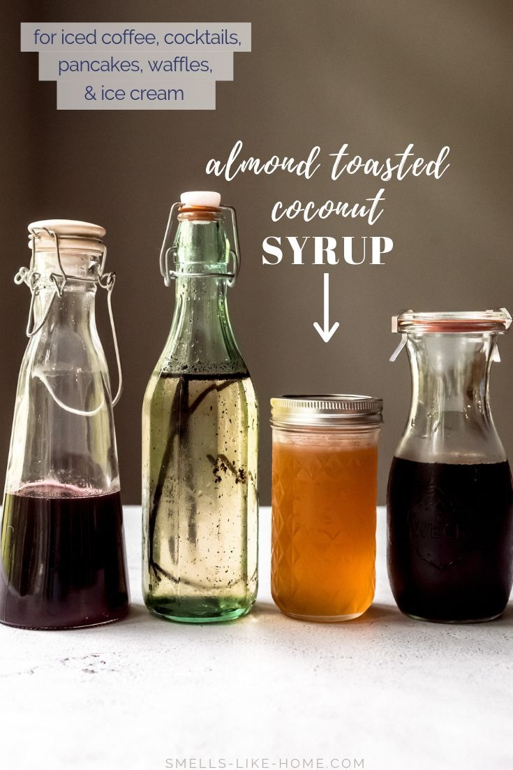 four different types of liquid in glass bottles with labels on the top and bottom, labeled homemade vanilla syrup for cold brew iced coffee