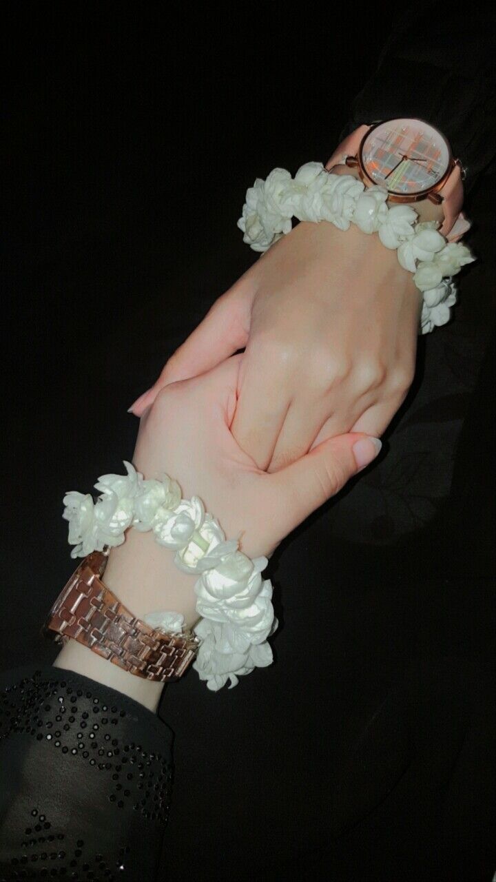 two hands holding each other while wearing bracelets