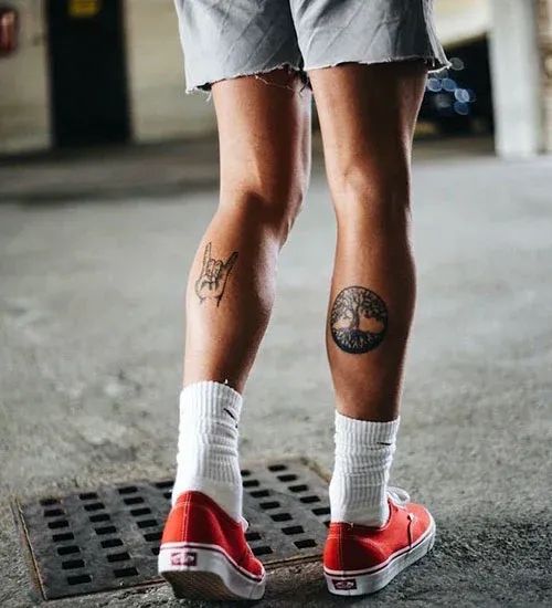 a person with tattoos standing on a skateboard