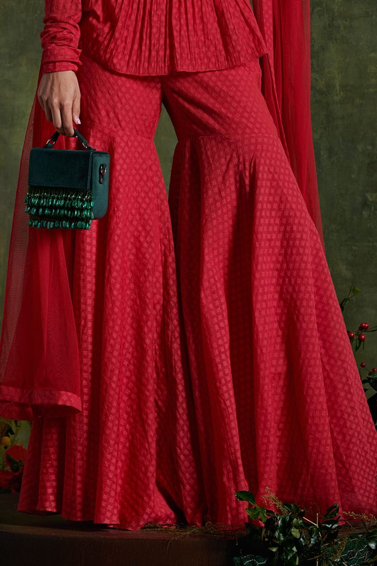 Hibiscus red peplum kurta highlighted with intricate floral embroidery, jacquard woven motifs, round neckline and full sleeves. Comes with chanderi jacquard sharara and net dupatta.
Component: 3
Pattern: Woven, Embroidered
Type Of Work: Floral
Neckline: Round
Sleeve Type: Full
Fabric: Kurta and Sharara: Chanderi Jacquard; Dupatta: Net
Color: Red
Other Details: 
Concealed hooks at the front hook
Note: The anarkali set and clutch bag shown in the image is not for sale
Occasion: Destination Wedding Kurta And Sharara, Ridhi Mehra, Hibiscus Red, Red Kurta, Floral Set, Sharara Set, Net Dupatta, Jacquard Weave, Full Sleeves