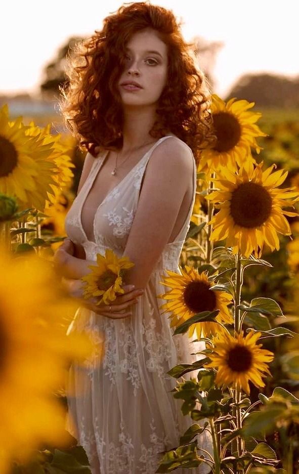 a woman standing in a field of sunflowers